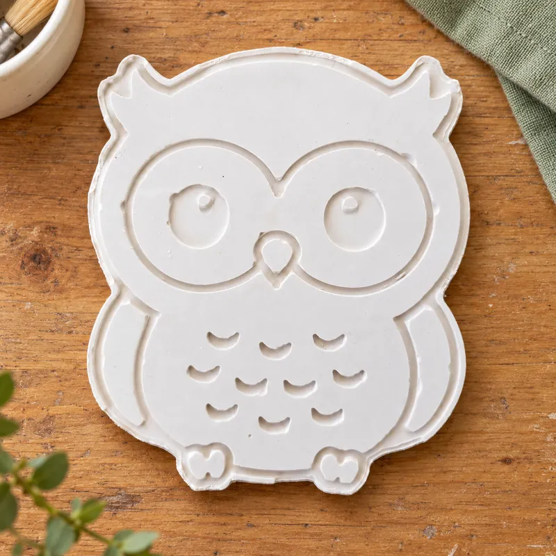 Unpainted Storybook Owl plaster figure on a wooden craft table