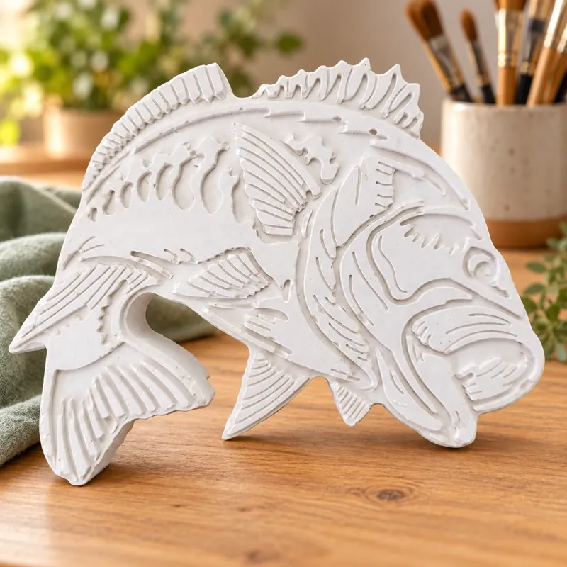 Unpainted Lake Spirit Fish plaster figure on a craft table