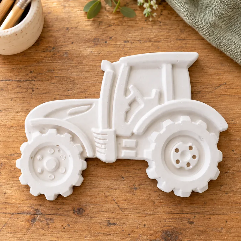 Unpainted Country Tractor plaster figure on a craft table