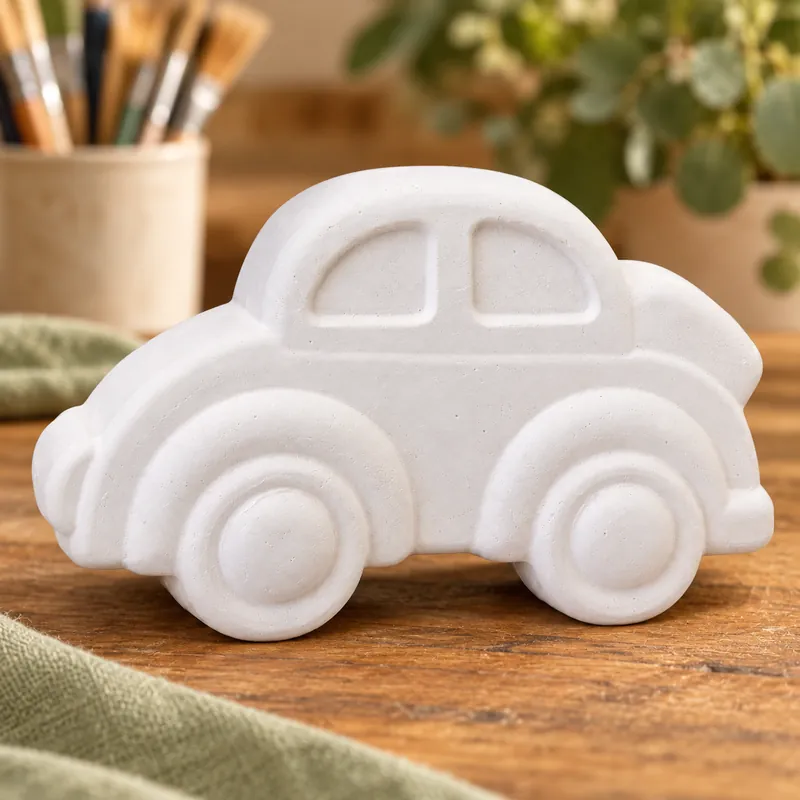 Unpainted Little City Car plaster figure on a craft table